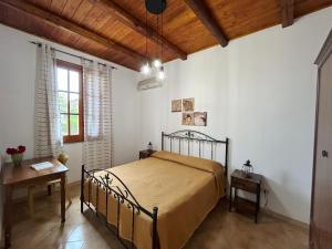 a bedroom with a bed and a table and a window at Garden Paradise near the sandy beach, parking & wifi in Marina dʼAvola