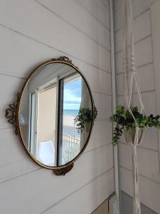 un espejo en el lateral de una pared con una ventana en Week end romantique FACE A LA MER, en Narbonne-Plage