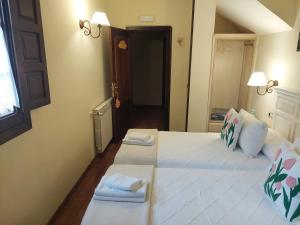 1 dormitorio con 2 camas y toallas. en El Valle Hotel Rural, en Sotillo del Rincón
