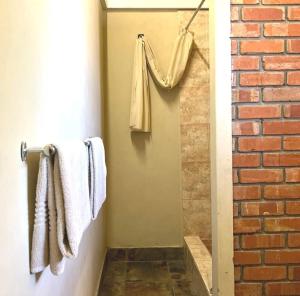 a bathroom with towels hanging on a wall at Thebe River Safaris in Kasane