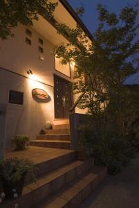 a house with stairs leading up to a door at Mashio Hotel & Resort in Oshima