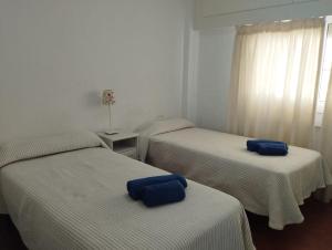 een kamer met twee bedden met blauwe kussens erop bij VERDEMAR 16 MENYBER in Nerja