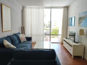 een woonkamer met een blauwe bank en een tv bij VERDEMAR 16 MENYBER in Nerja