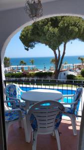 een tafel en stoelen op een balkon met uitzicht op de oceaan bij VERDEMAR 16 MENYBER in Nerja