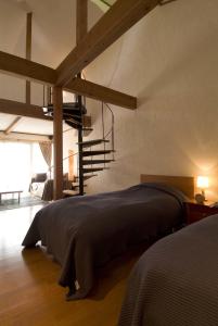 a bedroom with a large bed and a staircase at Mashio Hotel & Resort in Oshima