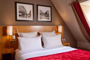Habitación de hotel con cama con almohadas blancas en Royal Saint Michel en París