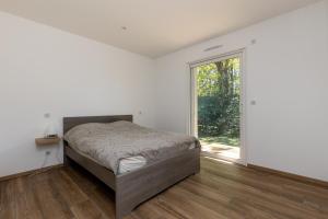 une chambre avec un lit et une grande fenêtre dans l'établissement Maison Moliets - Proche plage Adrénaline Parc, à Moliets-et-Maa