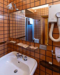 y baño con lavabo y espejo. en Hotel Terme, en Sarnano