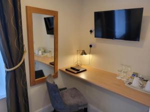 um quarto com uma secretária com um espelho e uma cadeira em Geckos Rest em Newquay