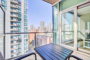 a balcony with a wooden table and chairs on it at Luxury 2BR Condo - Downtown City Views in Calgary