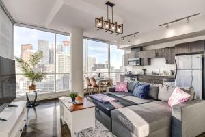 a living room with a couch and a kitchen at Luxury 2BR Condo - Downtown City Views in Calgary