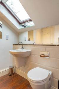 a bathroom with a toilet and a sink and a skylight at Mill Top in Ambleside +19 photos