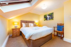 a bedroom with a large bed and a chair at Mill Top in Ambleside