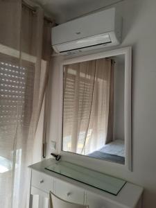 a mirror in a room with a window and a sink at apartamento perto do Santuário in Fátima