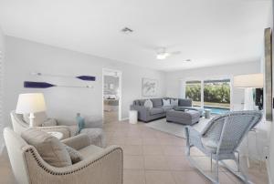 sala de estar blanca con sillas y sofá en Nautical home with pool, grill and steps to shops, en Marco Island