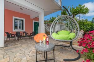 a patio with a wicker chair and a table at Take me Home country home by "elite" in Éxo Khóra