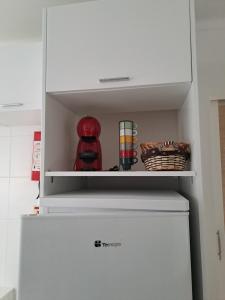 a white refrigerator with a shelf on top of it at apartamento perto do Santuário in Fátima