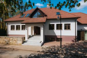 een wit huis met een rood dak bij Komandandi Apartments in Kuressaare