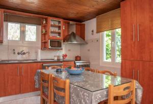 a kitchen with wooden cabinets and a table with chairs at Take me Home country home by "elite" in Éxo Khóra