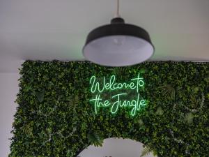a hanging light with a sign that reads welcome to the jungle at Large Group Central Apartment in Newcastle upon Tyne