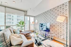ein Wohnzimmer mit einem Sofa und einem TV in der Unterkunft Luxury 2BR Condo - King Bed - Stunning City Views in Calgary