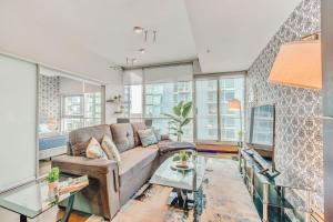 a living room with a couch and a table at Luxury 2BR Condo - King Bed - Stunning City Views in Calgary