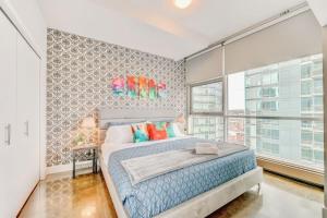 sypialnia z łóżkiem i dużym oknem w obiekcie Luxury 2BR Condo - King Bed - Stunning City Views w mieście Calgary