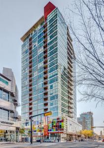 a tall building with glass windows on a city street at Luxury 2BR Condo - King Bed - Stunning City Views in Calgary