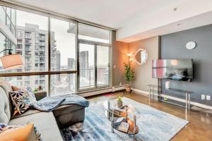 a living room with a couch and a large window at Modern 2BR Condo - King Bed - Downtown City Views in Calgary
