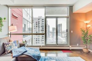 a living room with a large window at Modern 2BR Condo - King Bed - Downtown City Views in Calgary