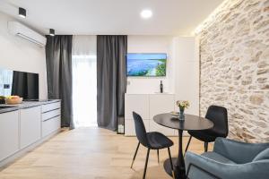 a kitchen and dining room with a table and chairs at Monsignore in Zadar