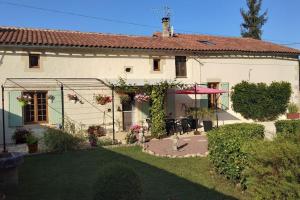 a white house with a garden and a patio at Large 3 bedroom Cottage near Ruffec in Bernac