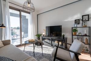 a living room with a couch and a tv at Moon Light 1-Bedroom Apartment in Larnaca in Larnaka