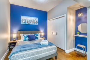 カルガリーにあるCozy 2BR Condo with King Bed and City Viewsの青い壁のベッド付きの青いベッドルーム1室