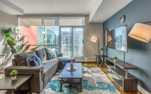 - un salon avec un canapé et une grande fenêtre dans l'établissement Cozy 2BR Condo with King Bed and City Views, à Calgary