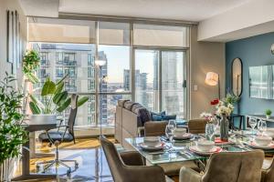 a living room with a table and chairs and a large window at Cozy 2BR Condo with King Bed and City Views in Calgary