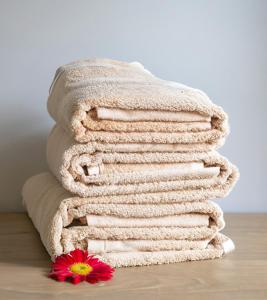 stos ręczników na podłodze z kwiatem w obiekcie Beautiful Apartment by Piccadilly Circus w mieście Edmonton
