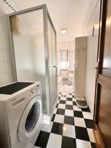 eine Waschmaschine im Bad mit einem karierten Boden in der Unterkunft Sailor House Arona in Arona