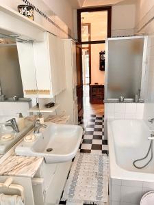 ein Badezimmer mit 2 Waschbecken und einer Badewanne in der Unterkunft Sailor House Arona in Arona