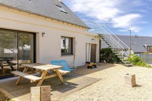 a patio with a table and chairs and a staircase at Ar Mor, votre pied à terre cocoon au cœur de ville in Paimpol