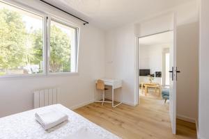 a bedroom with a bed and a desk and a window at Ar Mor, votre pied à terre cocoon au cœur de ville in Paimpol