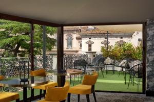 a balcony with tables and chairs and a view of a building at Hotel Barberini in Rome