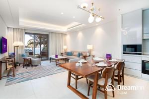 uma sala de jantar e sala de estar com mesa e cadeiras em Dream Inn - Address Beach Residence - Free Beach Access em Fujairah