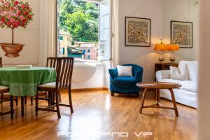 ein Wohnzimmer mit einem Tisch, Stühlen und einem Sofa in der Unterkunft Your Window on Portofino by PortofinoVip in Portofino