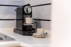 eine Kaffeemaschine und zwei Tassen auf der Theke in der Unterkunft Your Window on Portofino by PortofinoVip in Portofino