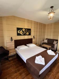 Family Hotel Emaly 2 في ساباريفا بانيا: غرفة نوم بسرير كبير وأريكة