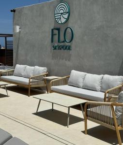 a group of chairs and tables in front of a sign at The Londoner Hotel St. Julian's in St. Julianʼs