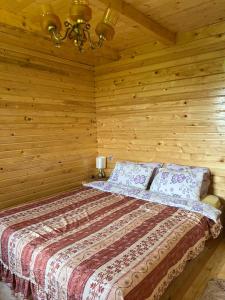 a bedroom with a bed in a wooden cabin at Kolibe Ćorić in Mojkovac