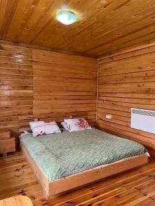 a bedroom with a bed in a wooden cabin at Kolibe Ćorić in Mojkovac