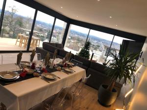 een eetkamer met een tafel en een groot raam bij La Villa in Brive-la-Gaillarde